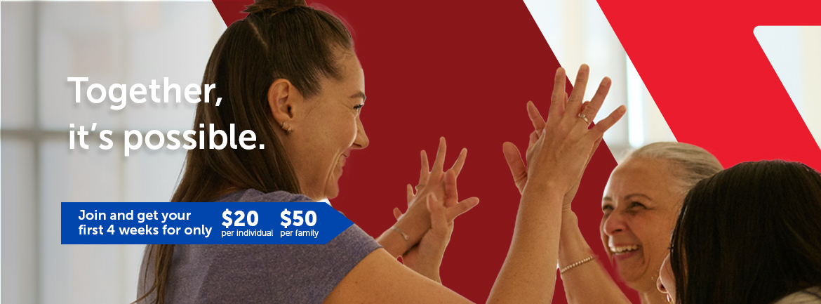 Three women smiling and giving each other high fives in a bright fitness studio, with a large red YMCA logo in the background. Text on the image reads: “Together, it’s possible. Join and get your first 4 weeks for only $20 per individual or $50 per family.”